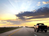 image of truck driving on road into sunset