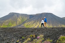 image of couple walking on a path with mountain range in the background